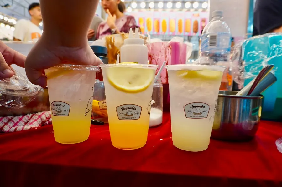 Iced drinks lined up at a live station with a red tablecloth